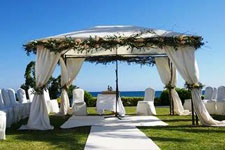 gazebo surrounded by white chairs with blue sky